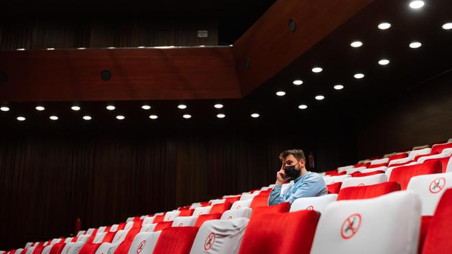masked_man_sitting_alone_in_empty_theater.jpg